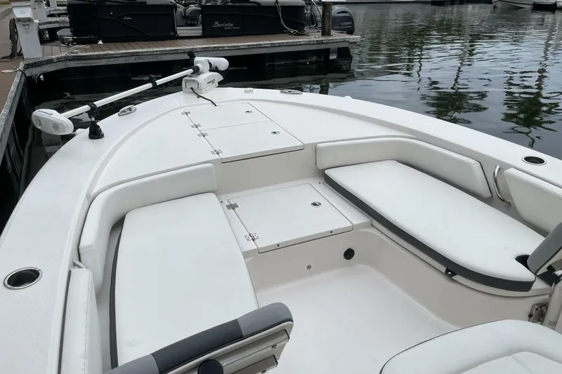 Slide: The Image of 2022 Robalo 246 Cayman SD boat interior with white seating and storage compartments. - 36