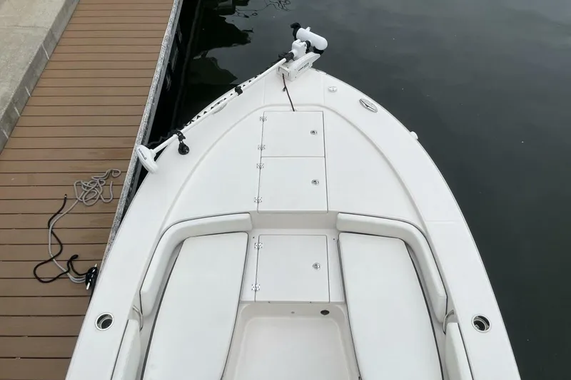 Slide: The Image of 2022 Robalo 246 Cayman SD boat docked, featuring spacious deck and seating. - 38