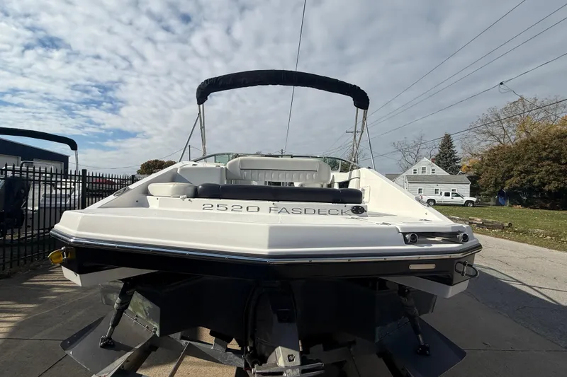 Slide: The Image of 2008 Regal 2520 FasDeck boat on trailer, parked outdoors under cloudy sky. - 23