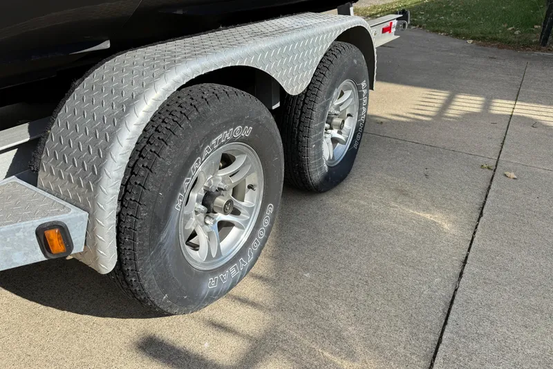 Slide: The Image of Trailer wheels of a 2008 Regal 2520 FasDeck boat on a concrete driveway. - 25