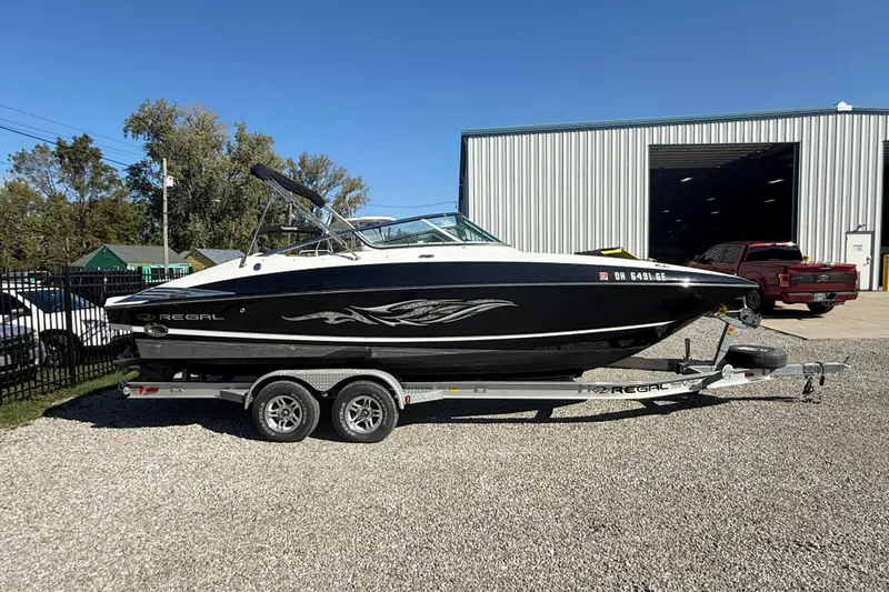 Slide: The Image of 2008 Regal 2520 FasDeck boat on trailer, parked outdoors near a warehouse. - 29
