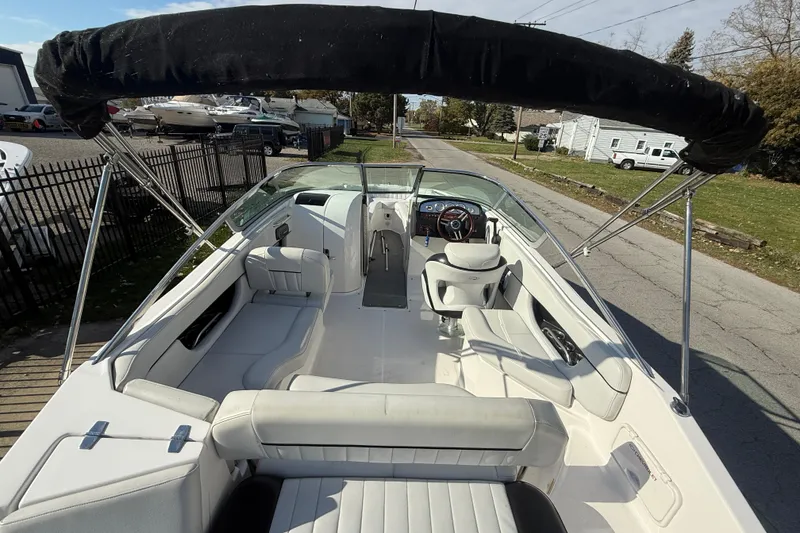 Slide: The Image of 2008 Regal 2520 FasDeck boat interior with seating and steering wheel, parked on a street. - 7