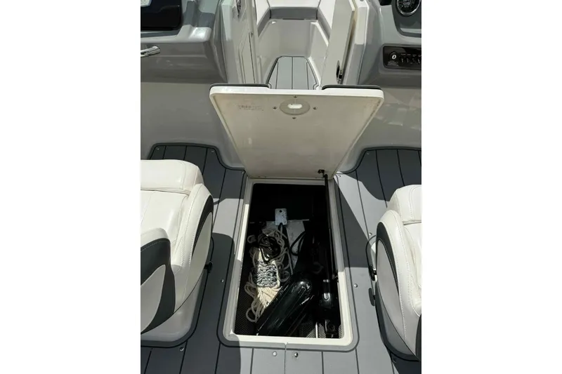 Slide: The Image of Open storage compartment in 2021 Chaparral 216 SSi boat, featuring a blue interior. - 13