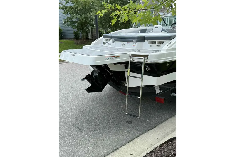 Slide: The Image of 2021 Chaparral 216 SSi boat interior storage compartment with open hatch and visible equipment. - 14