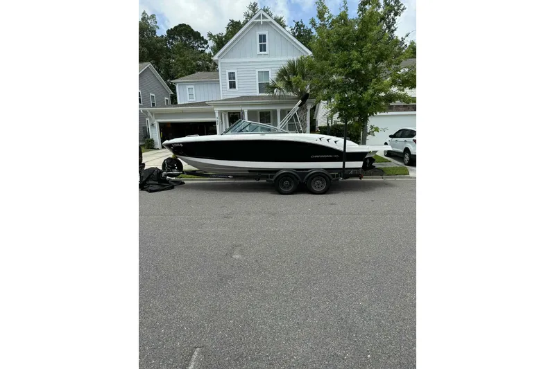 Slide: The Image of 2021 Chaparral 216 SSi boat on trailer, parked in residential driveway. - 2