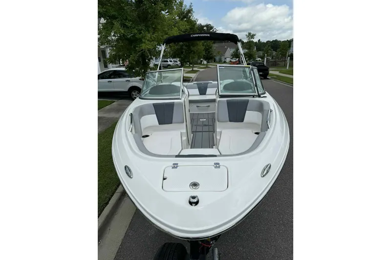 Slide: The Image of 2021 Chaparral 216 SSi boat on trailer, parked in suburban neighborhood. - 4