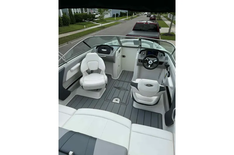 Slide: The Image of 2021 Chaparral 216 SSi boat interior with sleek seating and modern dashboard design. - 9
