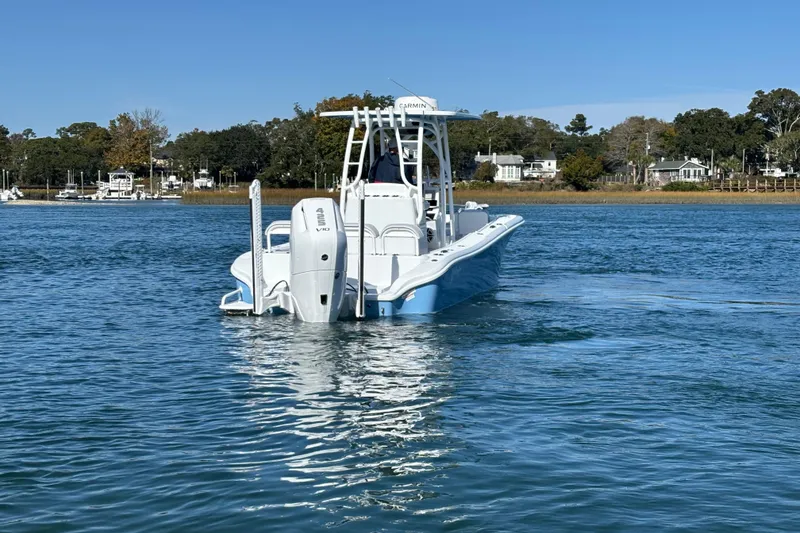Slide: The Image of 2026 Yellowfin 26 Hybrid boat on calm water, surrounded by trees and houses. - 11