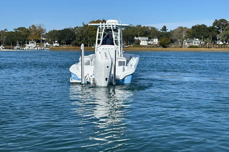 Slide: The Image of 2026 Yellowfin 26 Hybrid boat cruising on a calm blue lake with scenic background. - 12