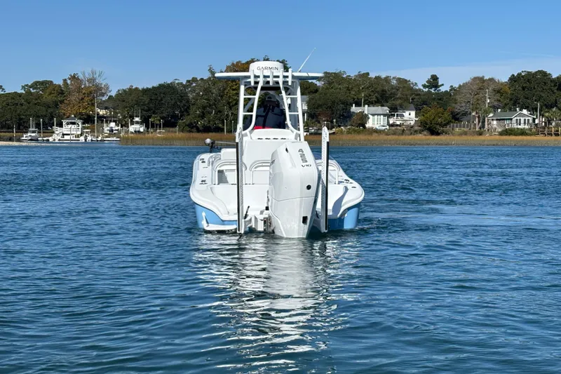 Slide: The Image of 2026 Yellowfin 26 Hybrid boat cruising on a calm lake with scenic shoreline. - 13