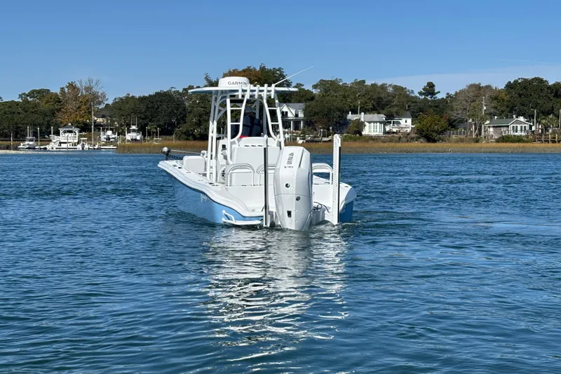 Slide: The Image of 2026 Yellowfin 26 Hybrid boat on calm water, with scenic shoreline background. - 15