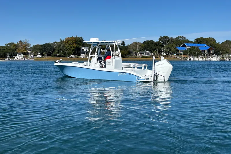 Slide: The Image of 2026 Yellowfin 26 Hybrid boat on calm water, with scenic shoreline background. - 17