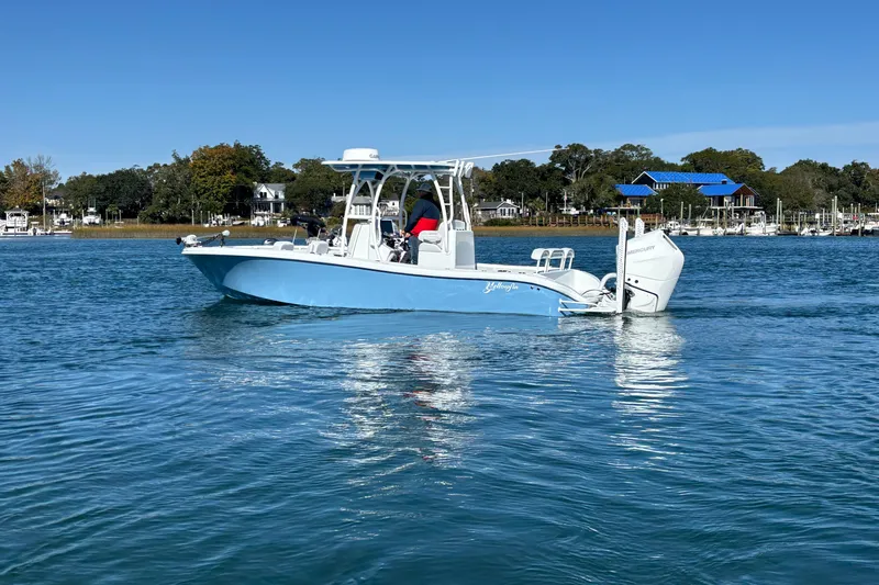 Slide: The Image of 2026 Yellowfin 26 Hybrid boat cruising on a calm blue lake under clear skies. - 18