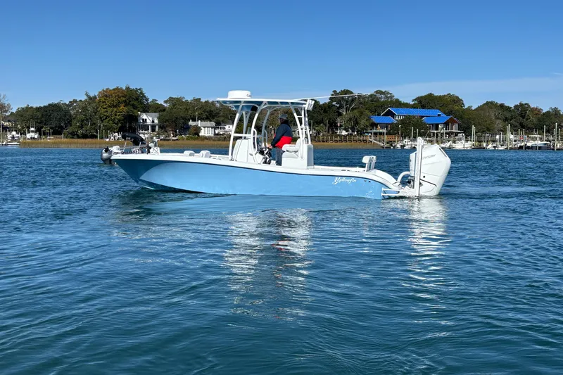 Slide: The Image of 2026 Yellowfin 26 Hybrid boat on calm water, with scenic shoreline background. - 19