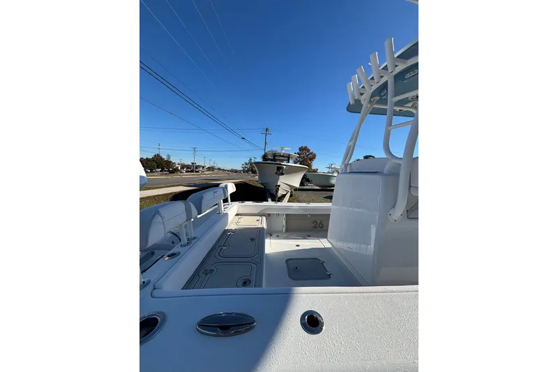 Slide: The Image of 2026 Yellowfin 26 Hybrid boat interior with seating and storage, under clear blue sky. - 26