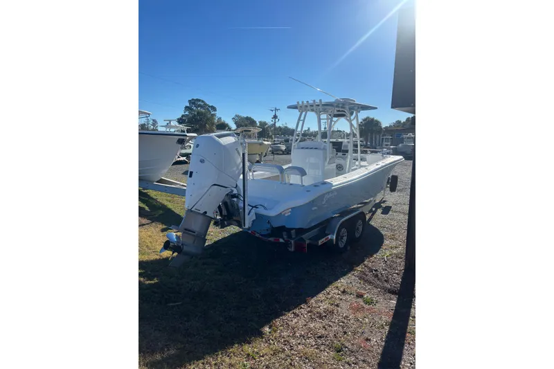 Slide: The Image of 2026 Yellowfin 26 Hybrid boat on calm water, with scenic shoreline background. - 4