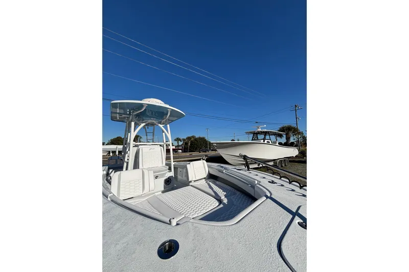 Slide: The Image of 2026 Yellowfin 26 Hybrid boat on calm water, surrounded by scenic shoreline. - 9