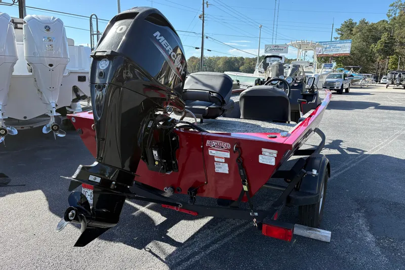 Slide: The Image of 2024 Bass Tracker Pro Team 170 boat with Mercury engine, parked outdoors. - 2