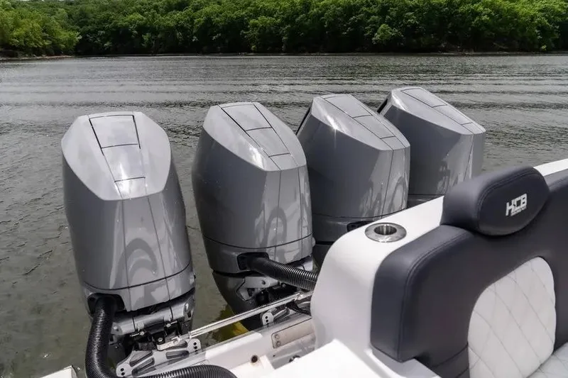 Slide: The Image of 2024 HCB 42 Lujo boat with four powerful outboard engines on a calm lake. - 16