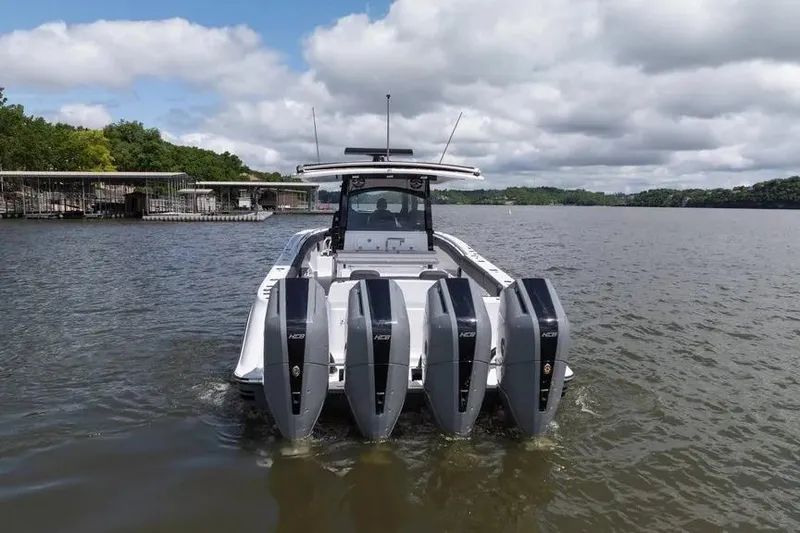 Slide: The Image of 2024 HCB 42 Lujo boat with four powerful outboard engines on a lake. - 2