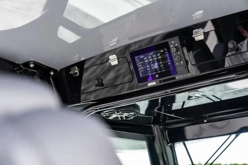 Slide: The Image of 2024 HCB 42 Lujo boat dashboard with digital display and sleek black design. - 24