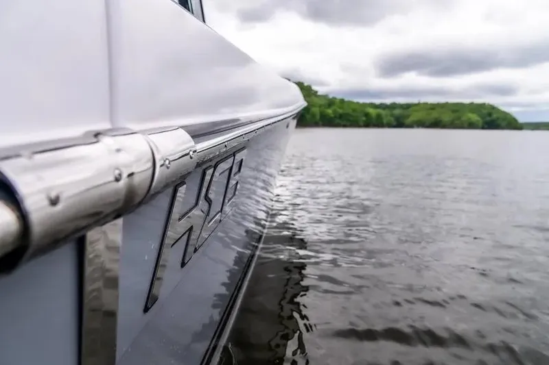 Slide: The Image of 2024 HCB 42 Lujo boat on calm water, side view with logo. - 41