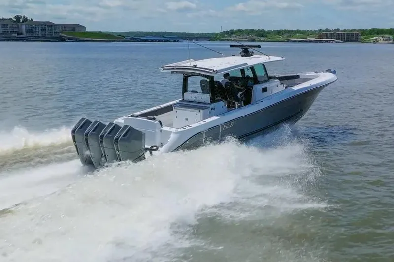 Slide: The Image of 2024 HCB 42 Lujo boat cruising on a lake with powerful engines. - 5