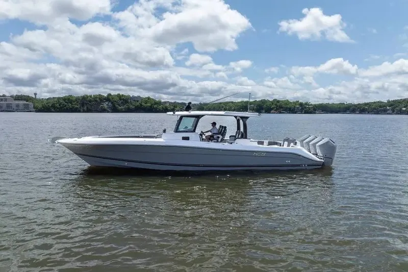 Slide: The Image of 2024 HCB 42 Lujo boat on a calm lake under a cloudy sky. - 8
