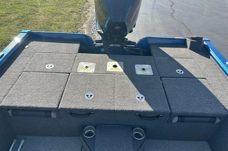 Slide: The Image of 2024 Lund 2075 Pro-V Bass XS boat deck with storage compartments and motor. - 10