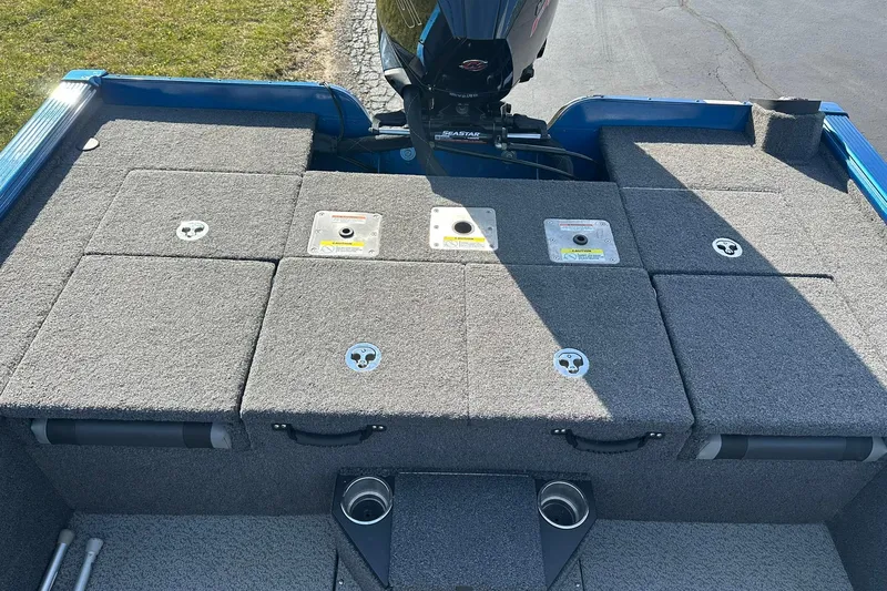 Slide: The Image of 2024 Lund 2075 Pro-V Bass XS boat deck with storage compartments and motor. - 11