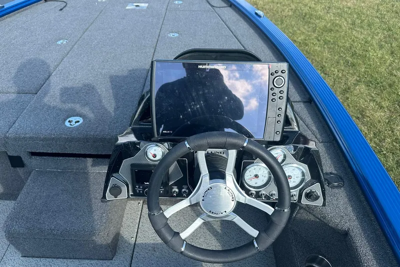 Slide: The Image of 2024 Lund 2075 Pro-V Bass XS boat dashboard with steering wheel and navigation display. - 14