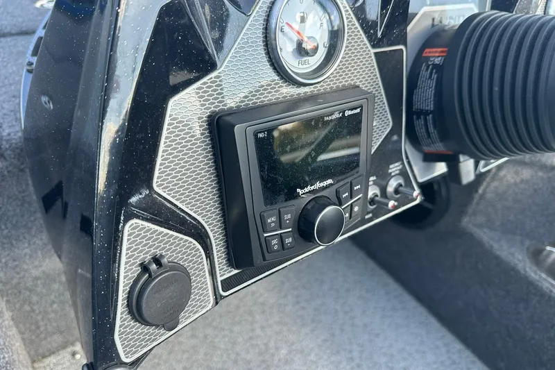 Slide: The Image of 2024 Lund 2075 Pro-V Bass XS dashboard with Rockford Fosgate audio system and fuel gauge. - 15