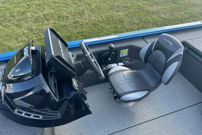 Slide: The Image of 2024 Lund 2075 Pro-V Bass XS boat interior with steering console and cushioned seat. - 17