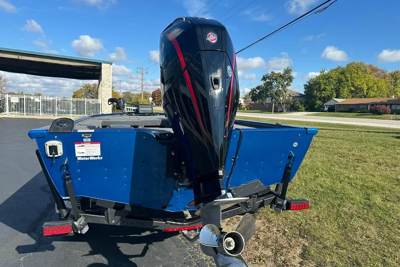 Slide: The Image of 2024 Lund 2075 Pro-V Bass XS boat with powerful outboard motor, parked outdoors. - 3