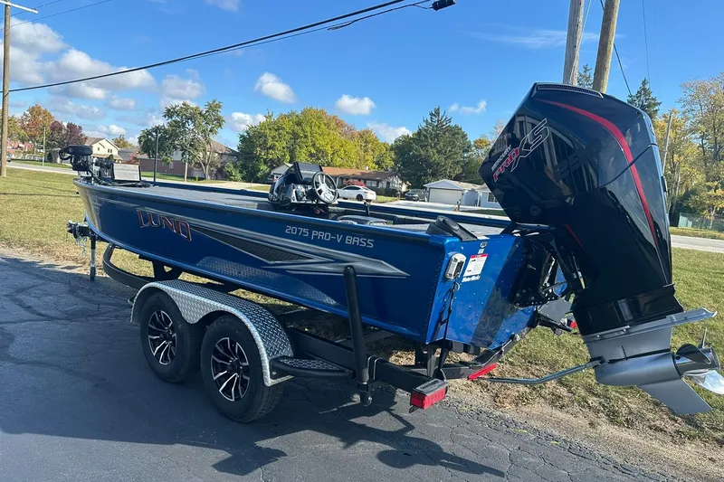 Slide: The Image of 2024 Lund 2075 Pro-V Bass XS boat on trailer, parked outdoors. - 4