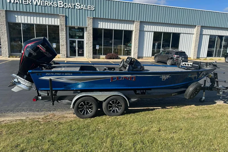 Slide: The Image of 2024 Lund 2075 Pro-V Bass XS boat on trailer outside dealership. - 5