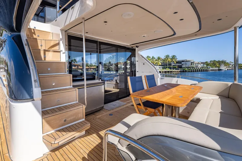 Slide: The Image of Luxurious 2023 Princess Y72 yacht deck with seating, table, and scenic waterfront view. - 1
