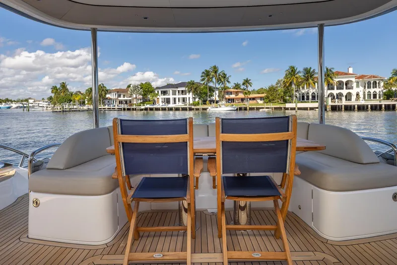 Slide: The Image of Luxury yacht Princess Y72 deck with seating, overlooking waterfront homes and palm trees. - 19