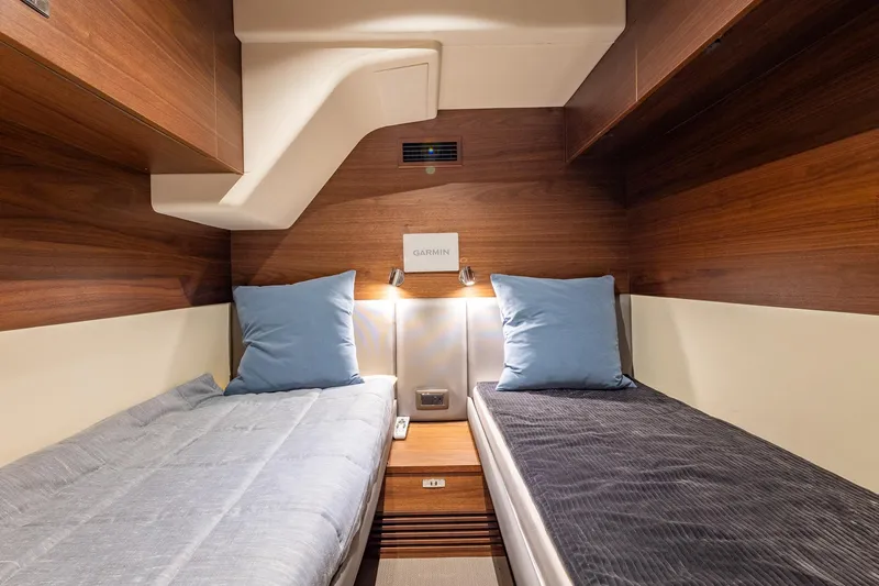 Slide: The Image of Luxurious twin cabin interior of 2023 Princess Y72 yacht with wooden finish and blue pillows. - 68