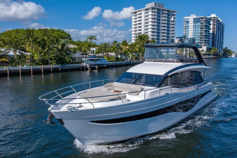 Slide: The Image of Luxury 2023 Princess Y72 yacht cruising near waterfront buildings and palm trees. - 7