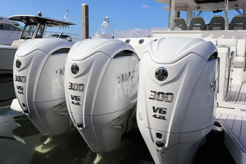 Slide: The Image of 2022 Regal 38 SAV boat with triple Yamaha outboard engines docked at marina. - 16