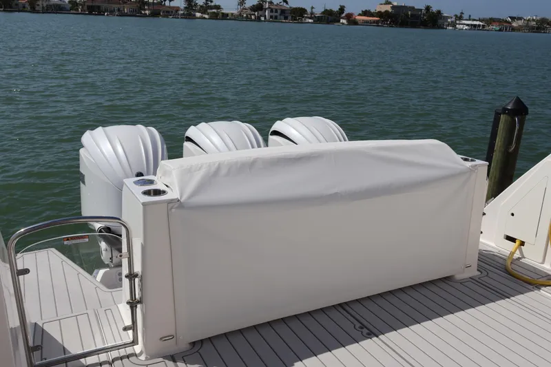 Slide: The Image of 2022 Regal 38 SAV boat with covered outboard engines on a sunny waterfront. - 19
