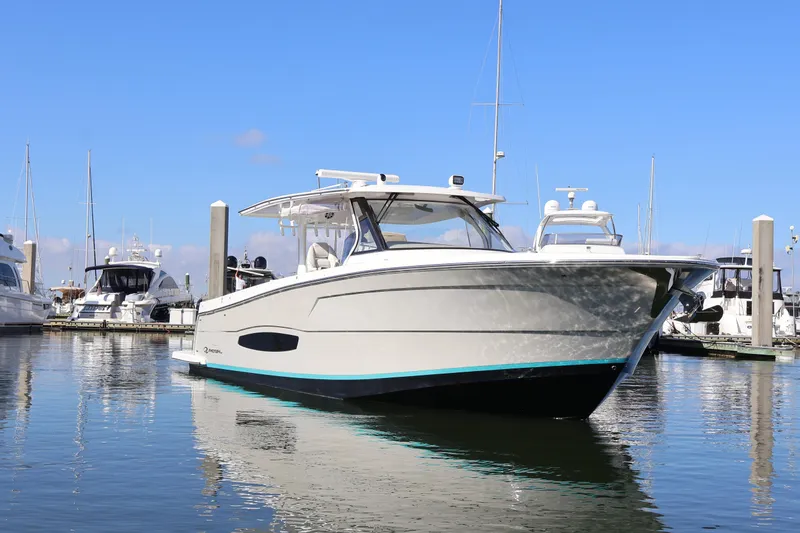 Slide: The Image of 2022 Regal 38 SAV boat docked in marina under clear blue sky. - 2