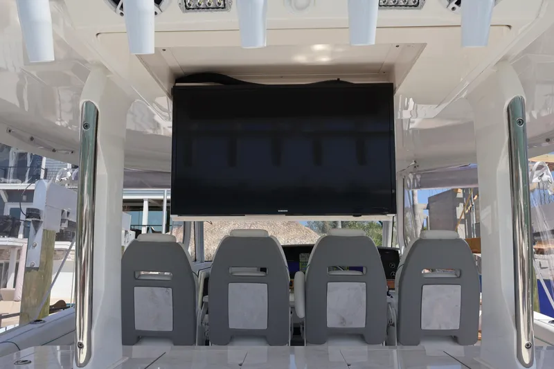 Slide: The Image of 2022 Regal 38 SAV boat interior with mounted TV and seating area. - 39