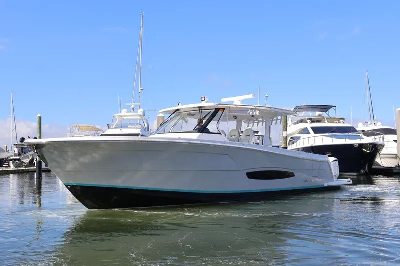 Slide: The Image of 2022 Regal 38 SAV boat docked in marina with triple Yamaha outboard engines. - 5
