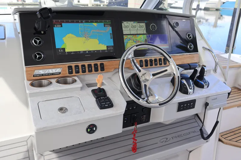 Slide: The Image of 2022 Regal 38 SAV boat helm with advanced navigation displays and controls at marina. - 63