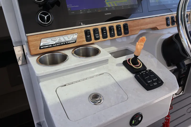 Slide: The Image of 2022 Regal 38 SAV boat controls with chrome accents on a white console. - 66