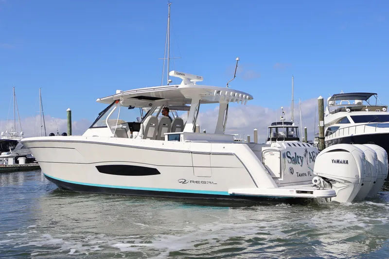 Slide: The Image of 2022 Regal 38 SAV boat docked in marina, clear blue sky background. - 7