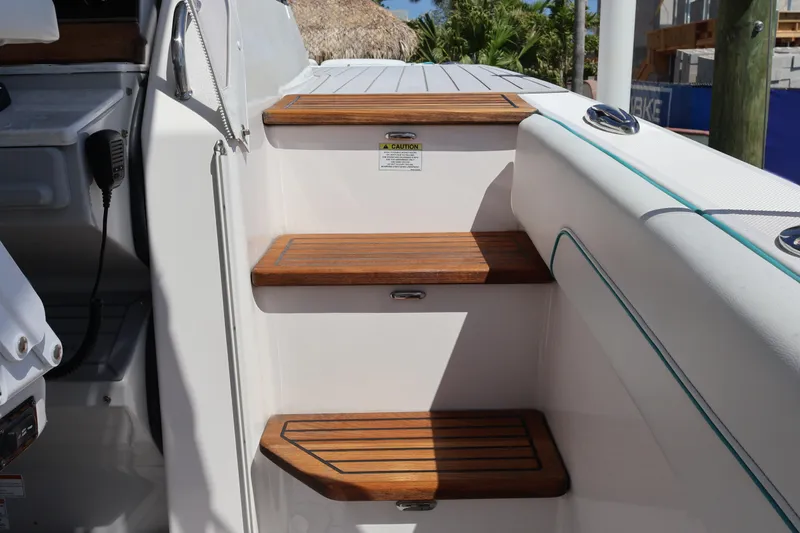 Slide: The Image of Wooden steps on a 2022 Regal 38 SAV boat deck, featuring sleek design elements. - 72