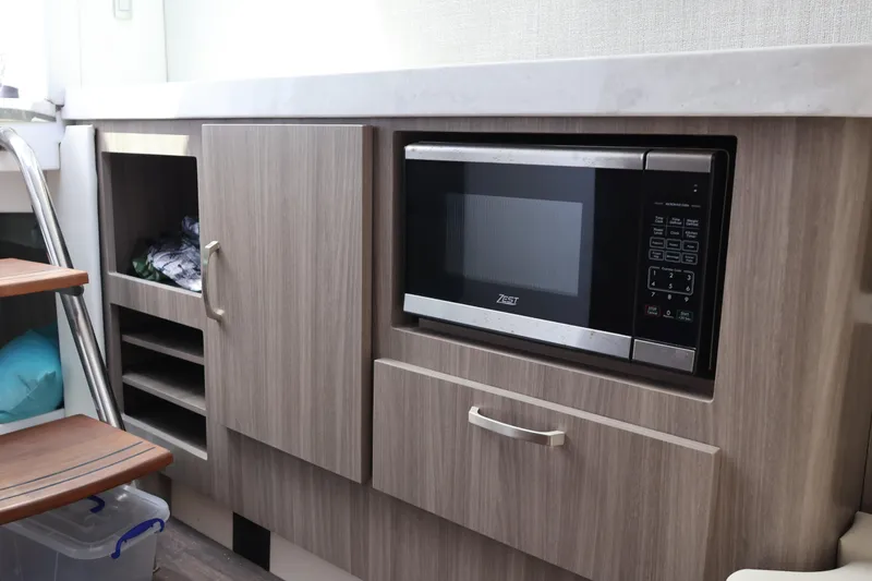 Slide: The Image of 2022 Regal 38 SAV interior with microwave, wood cabinetry, and decorative cushions. - 78